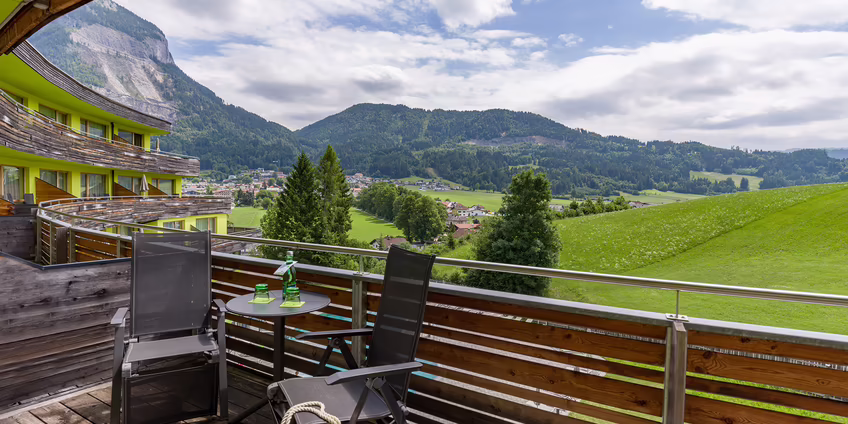Offener Balkon mit Blick auf grüne Wiesen und Berge