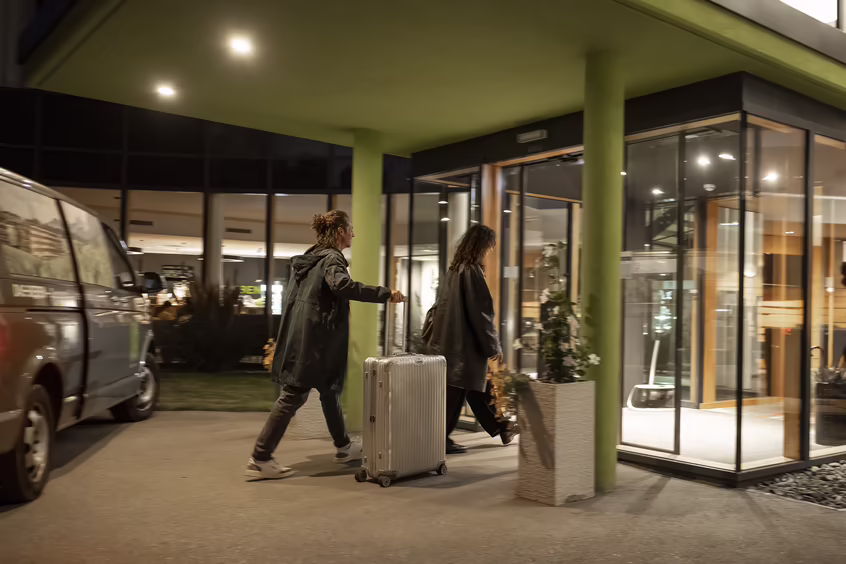 Gäste betreten das Hotel mit Gepäck