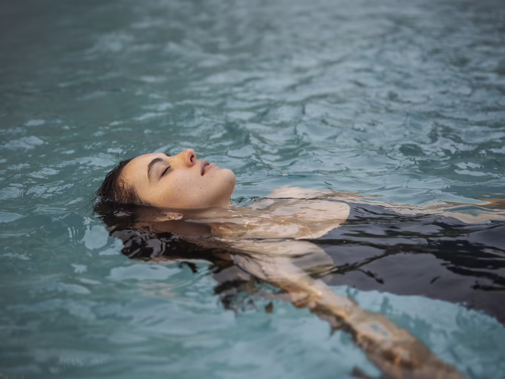 Frau entspannt im Wasser im Wellnessbereich des Hotels DAS SIEBEN