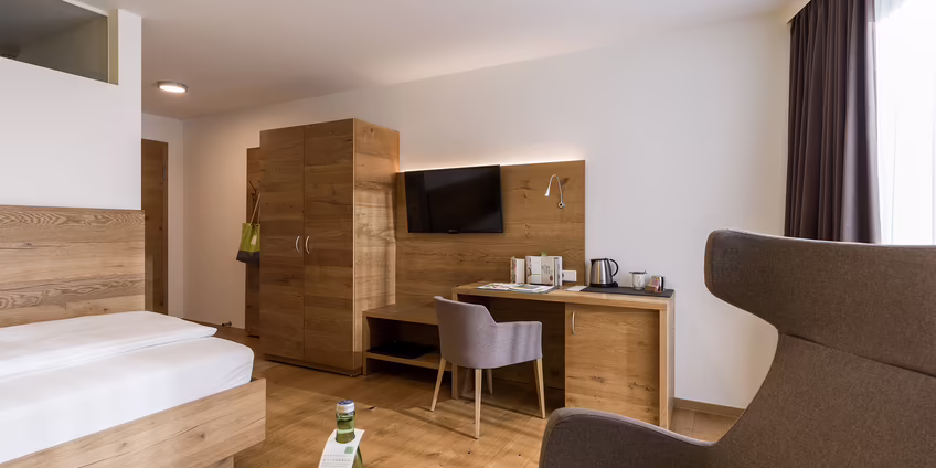 Hotelzimmer mit Einzelbett, Schreibtisch und Sitzgelegenheit in ruhiger Atmosphäre