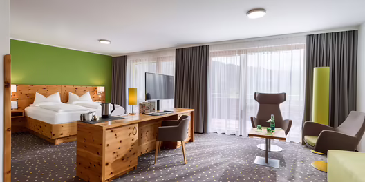 Großzügige Junior Suite mit Doppelbett, Sofa und großen Fensterfronten