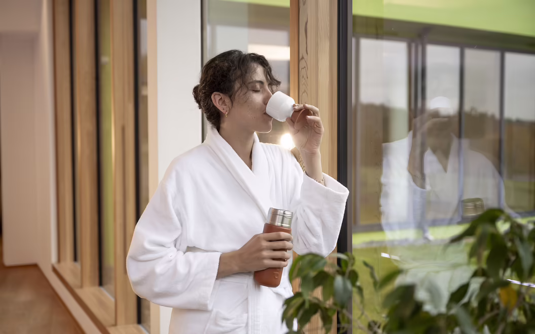 Frau im Bademantel trinkt Tee im Wellnessbereich im DAS SIEBEN