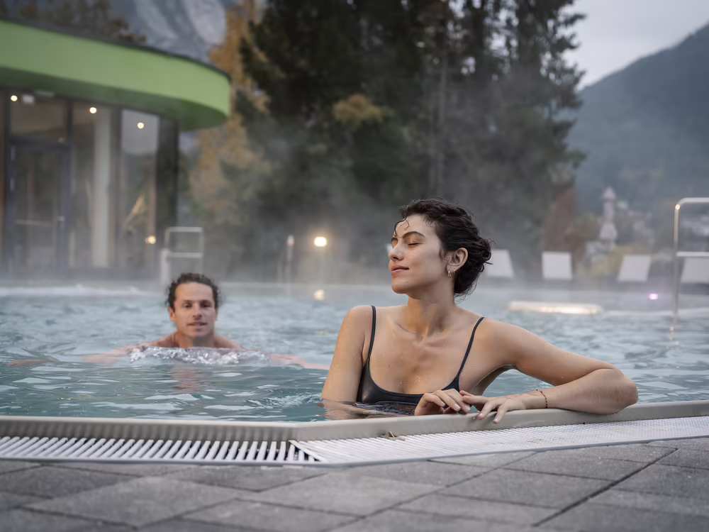  Guests relax in the outdoor pool with a view of nature
