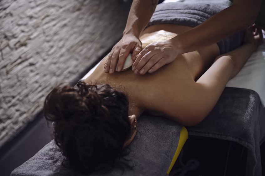 Nahaufnahme einer Rückenmassage auf einer Spa-Liege im DAS SIEBEN