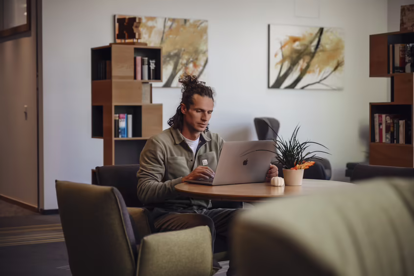 Mann arbeitet mit Laptop im Loungebereich