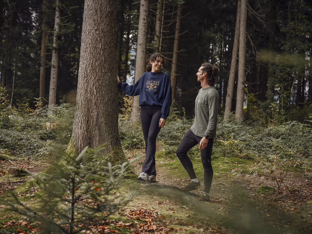 Zwei Personen stehen im Wald und betrachten die Natur