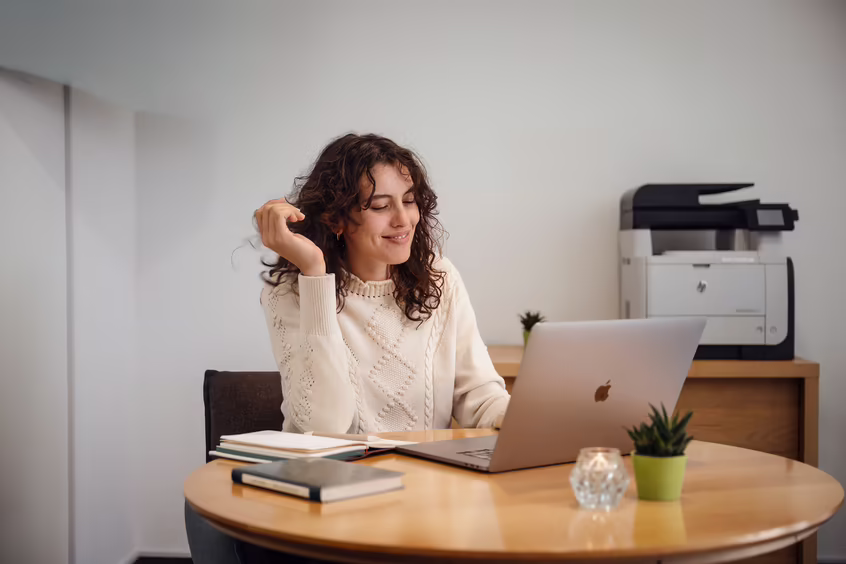 Frau arbeitet mit Laptop an einem Tisch